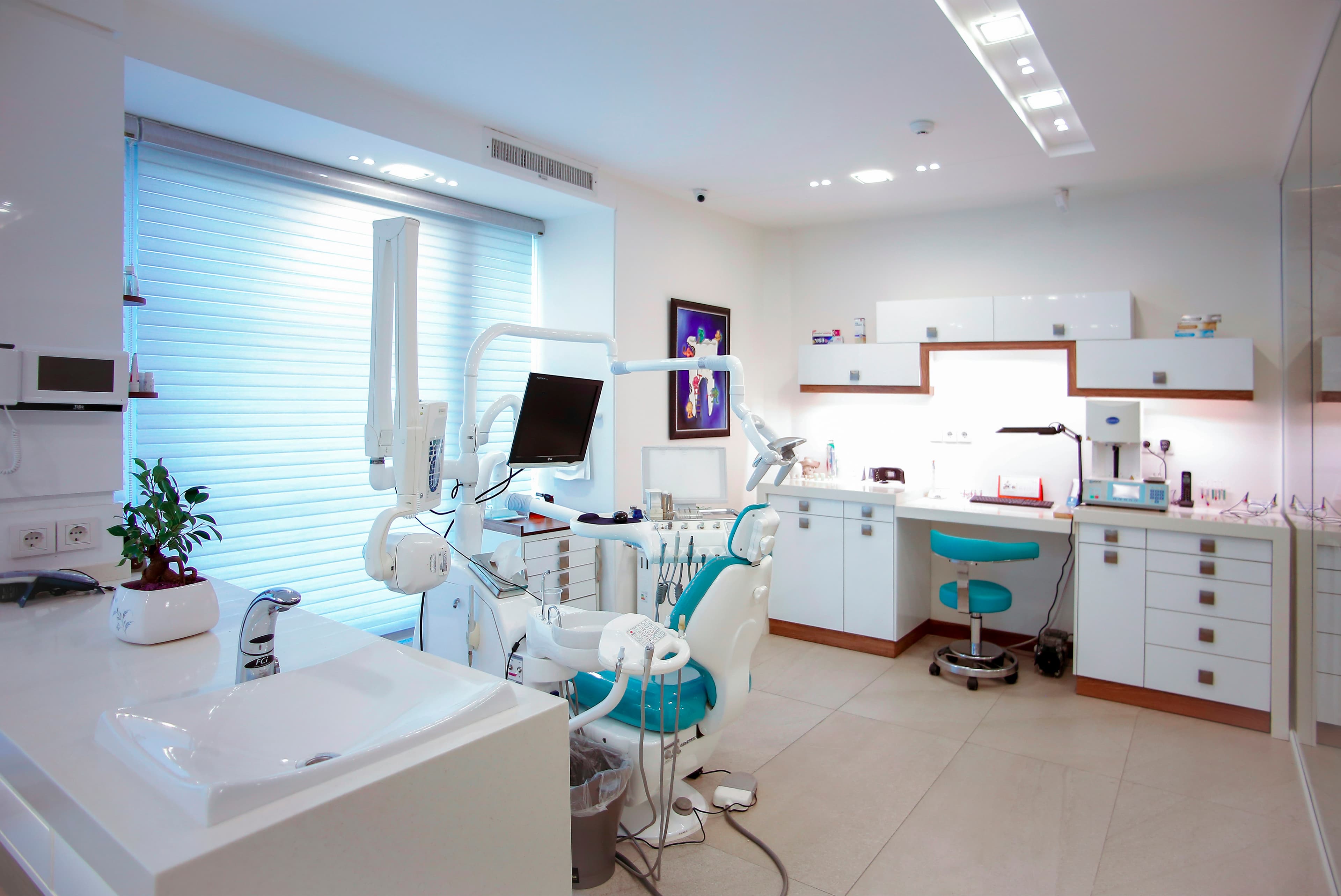 Consultorio dental moderno con sillón y equipo.