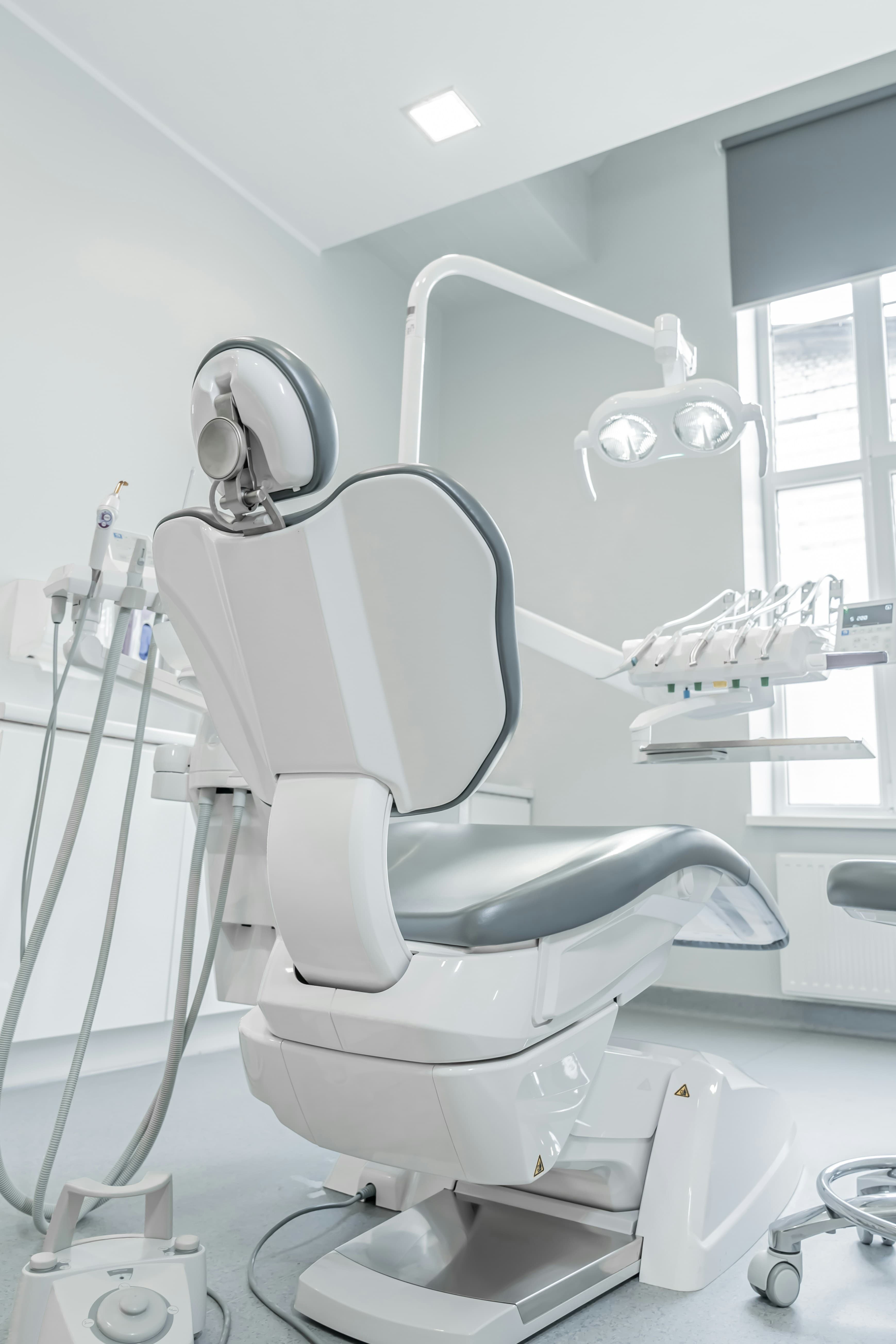 Sillón dental blanco junto a una ventana.