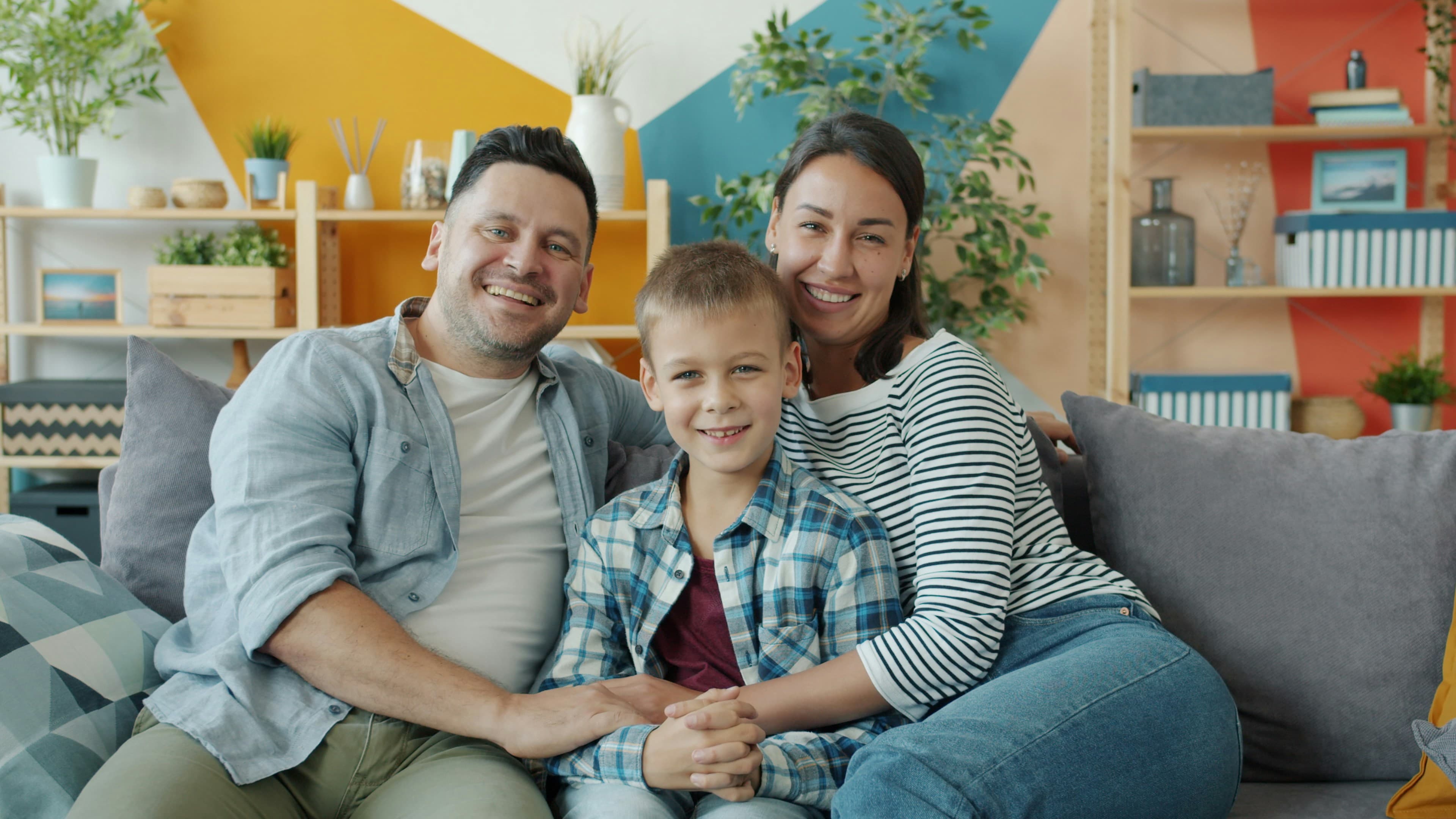 Familia de tres sentada en un sillón.