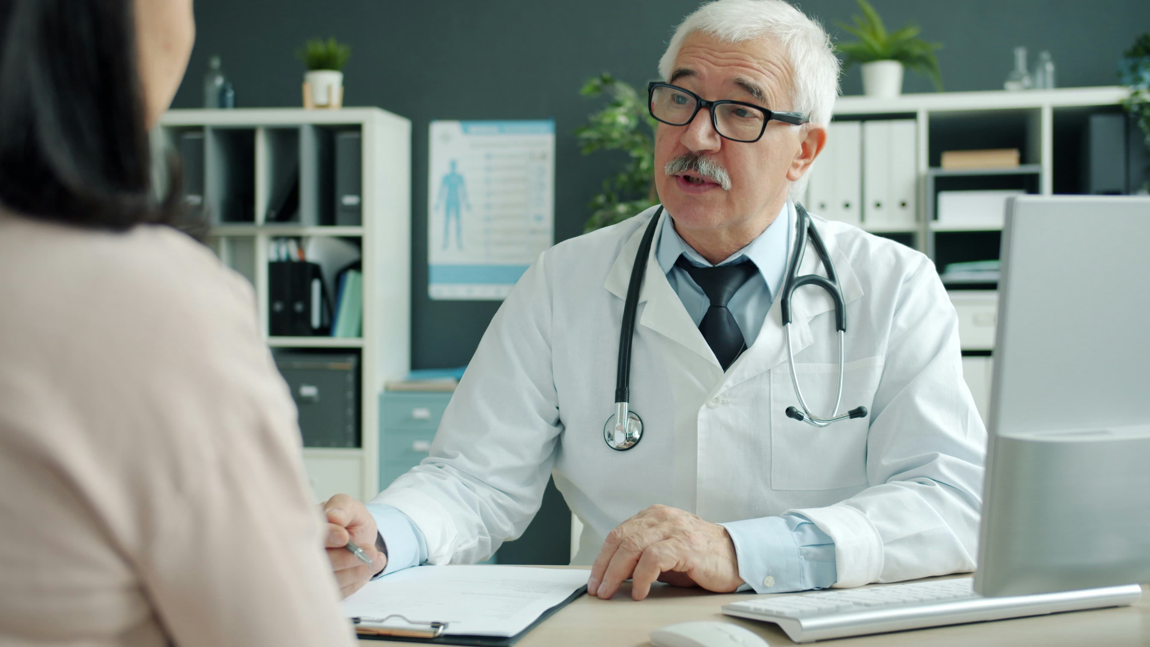 Médico conversando con un paciente en su oficina.